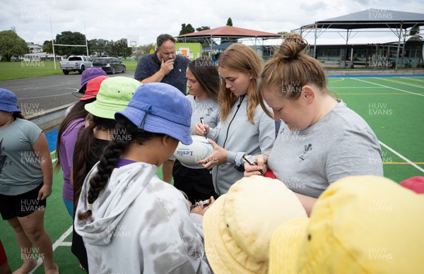 281022 - Wales Women Rugby School Engagement Event at Kamo Primary School - Wales’ Caryl Thomas, Niamh Terry, and Kayleigh Powell sign autographs as they meet the children at Kamo Primary School in Whangarei during a visit to take part in rugby activities