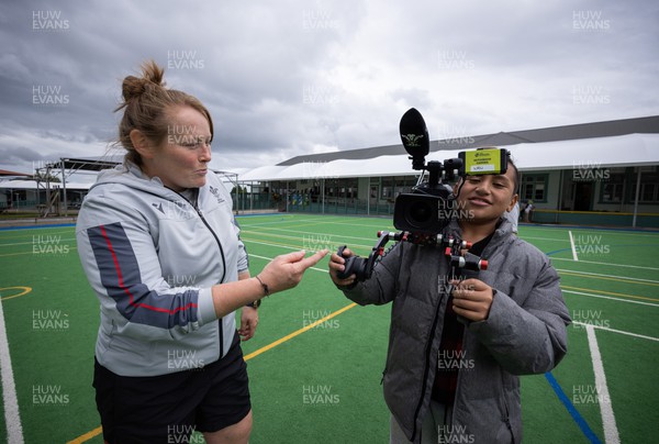 281022 - Wales Women Rugby School Engagement Event at Kamo Primary School - One pupil at Kamo Primary School in Whangarei gets a lesson in video interviewing Wales rugby player Caryl Thomas from Wales team videographer Cari Morris during a rugby coaching session with Wales players 