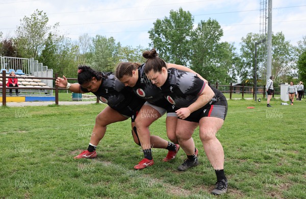 250423 - Wales Women Rugby Training Session - Sisilia Tuipulotu, Carys Phillips and Abbey Constable work together along with Wales assistant coach Mike Hill and Cerys Hale during a training session at Parma Rugby Club ahead of the TicTok Women’s 6 Nations match against Italy