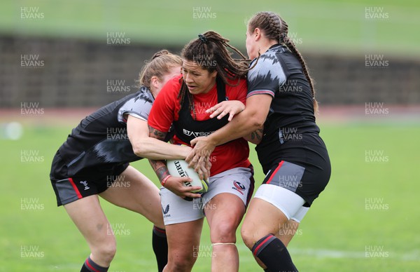 300922 - Wales Women Rugby Training Session - USA’s Katana Howard is held by Wales’ Lisa Neumann and Carys Phillips during a combined training session ahead of the start of the Women’s Rugby World Cup