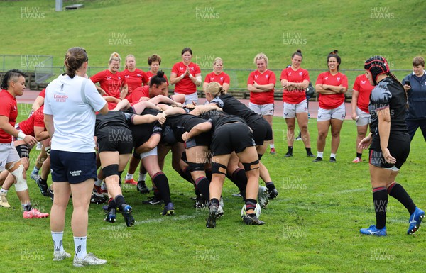 300922 - Wales Women Rugby Training Session - USA team members look on as their team mates and Wales contest a scrum during a combined training session ahead of the start of the Women’s Rugby World Cup