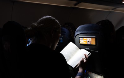 200325  Wales Women Rugby Squad travel to Edinburgh - Kelsey Jones reads on the flight from Bristol as Wales head to Edinburgh for the opening match of the Women’s 6 Nations against Scotland