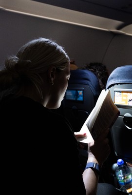 200325  Wales Women Rugby Squad travel to Edinburgh - Kelsey Jones reads on the flight from Bristol as Wales head to Edinburgh for the opening match of the Women’s 6 Nations against Scotland