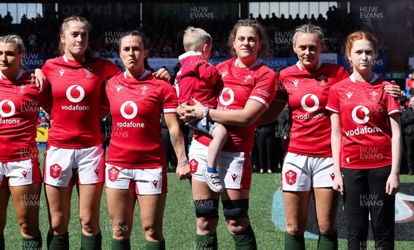 150423 - Wales v England, TicTok Women’s 6 Nations - Left to right, Lowri Norkett of Wales, Lisa Neumann of Wales, Ffion Lewis of Wales, Natalia John of Wales with Morgan, and Hannah Jones of Wales with match mascot line up for the anthems