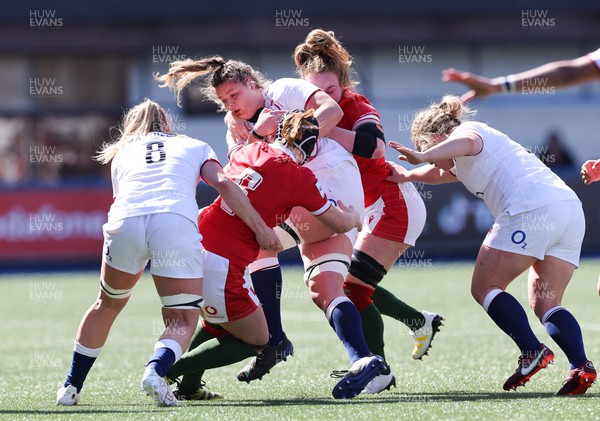 150423 - Wales v England, TicTok Women’s 6 Nations - Bethan Lewis of Wales and Abbie Fleming of Wales tackle Sarah Beckett of England