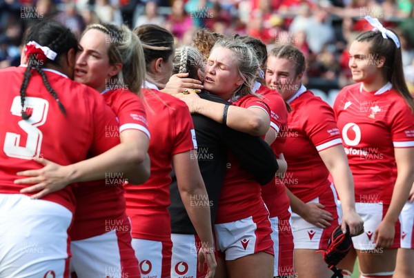 150423 - Wales v England, TicTok Women’s 6 Nations - Wales team members embrace at the end of the match
