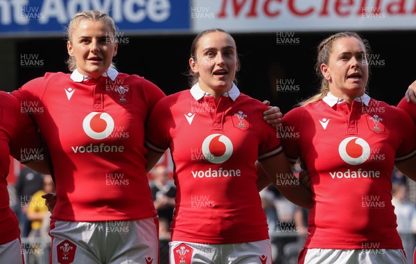 281023 - Wales Women v New Zealand Women, WXV1 -  Left to right, Carys Williams-Morris, Nel Metcalfe and Kat Evans line up for the anthems at the start of the match