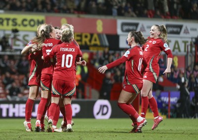 250225 - Wales v Sweden - UEFA Women's Nations League - Kayleigh Barton of Wales (9) celebrates scoring the equalising penalty with teammates