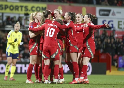 250225 - Wales v Sweden - UEFA Women's Nations League - Kayleigh Barton of Wales (9) celebrates scoring the equalising penalty with teammates