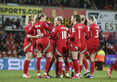 250225 - Wales v Sweden - UEFA Women's Nations League - Kayleigh Barton of Wales (9) celebrates scoring the equalising penalty with teammates