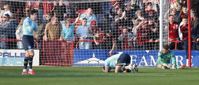 210326 - Walsall v Newport County - Sky Bet League 2 - Tom Davies of Newport and Goalkeeper Jordan Wright are floored with Anthony Glennon of Newport with his face in his shirt