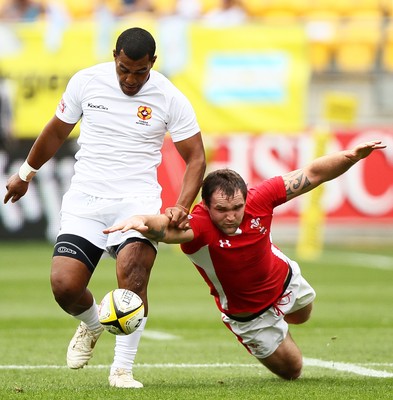 03.02.12 - Hertz Wellington Sevens - Wales' Rhys Shellard tries to gather the ball as Tonga's Vaea Poteki looks on. 