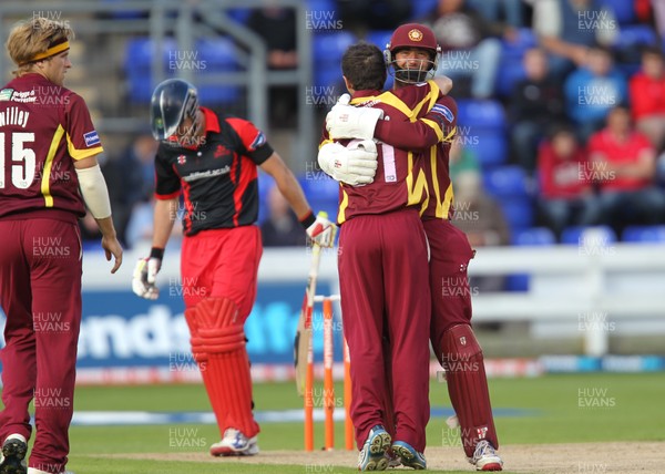 300612 - Welsh Dragons v Northants Steelbacks, Friends Life T20 - Northants Steelbacks David Murphy and Con de Lange celebrate the wicket of James Harris