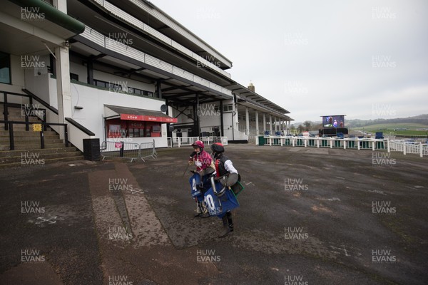 090121 - 2020 Coral Welsh Grand National Meeting - Jockeys make their way back to the Jockey's Rooms through empty stands at Chepstow Racecourse after of one of the races