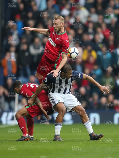 070418 - West Bromwich Albion v Swansea City, Premier League - Mike van der Hoorn of Swansea City is upended as he competes for the ball with Kyle Naughton of Swansea City against Salomon Rondon of West Bromwich Albion