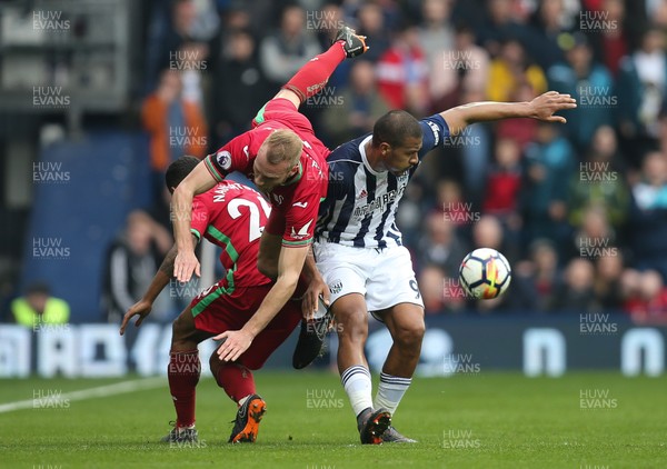 070418 - West Bromwich Albion v Swansea City, Premier League - Mike van der Hoorn of Swansea City is upended as he competes for the ball with Kyle Naughton of Swansea City against Salomon Rondon of West Bromwich Albion