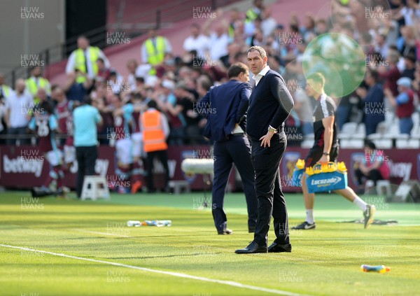 080417 - West Ham United v Swansea City - Premier League  -  Swansea manager Paul Clement is dejected as West Ham players celebrate the first goal behind him  