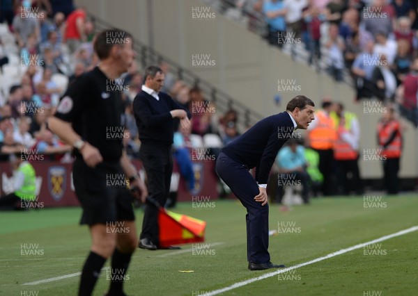 080417 - West Ham United v Swansea City - Premier League  -   West Ham manager Slaven Bilic waits anxiously for the final whistle whilst Paul Clement checks his watch behind  