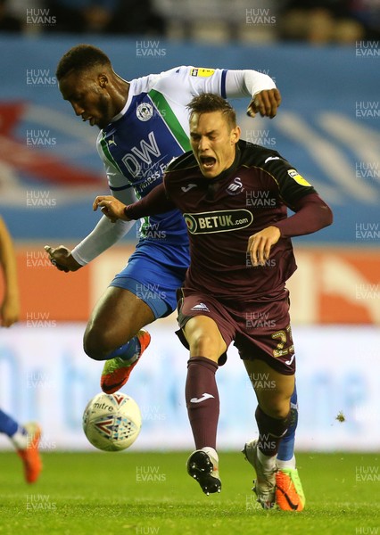 021018 - Wigan Athletic v Swansea City - SkyBet Championship - Connor Roberts of Swansea City is tackled by Cheyenne Dunkley of Wigan