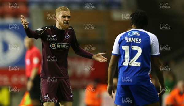 021018 - Wigan Athletic v Swansea City - SkyBet Championship - Oli McBurnie of Swansea City has words with Reece James of Wigan