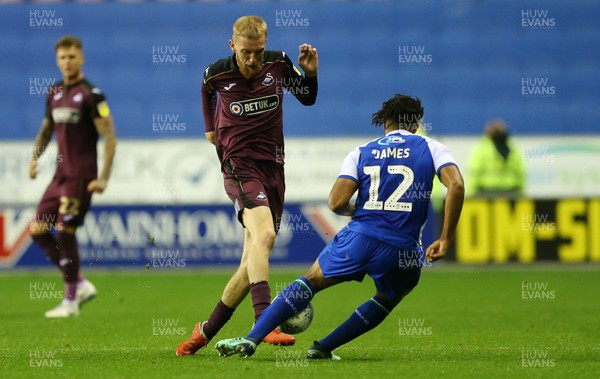 021018 - Wigan Athletic v Swansea City - SkyBet Championship - Oli McBurnie of Swansea City is tackled by Reece James of Wigan