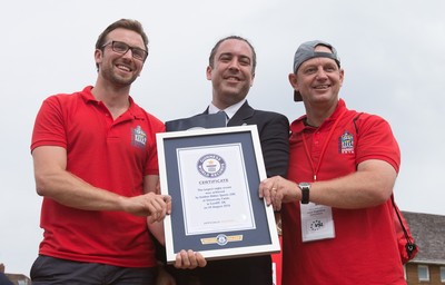 240816 - World Record attempt for the Largest Rugby Scrum - Jack Brockbank, adjudicator for Guinness World Records, presents the certificate for the new World Record for the Largest Rugby Scrum at 1297 people to Paul Guest, Festival Director, left and Mark Marriott, Scrum co-ordinator at the Golden Oldies World Rugby Festival in Cardiff