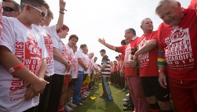 240816 - World Record attempt for the Largest Rugby Scrum - Participants wait to bind together as the attempt for the Worlds Largest Rugby Scrum gets underway at the Golden Oldies World Rugby Festival in Cardiff The new record of 1297 was successful