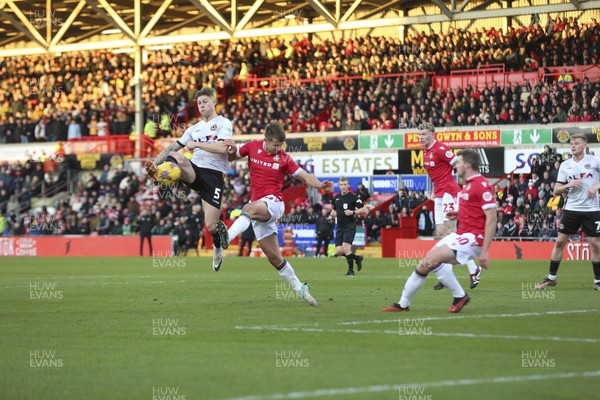 231223 - Wrexham v Newport County - Sky Bet League 2 - James Clarke challenged by Max Cleworth