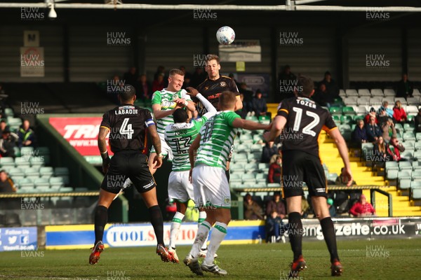 100318 - Yeovil Town v Newport County - EFL SkyBet League 2 - Micky Demetriou of Newport County and Alex Fisher of Yeovil Town compete for a high ball 