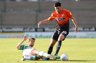 100718 - Yeovil Town v Swansea City - Pre Season Friendly - Cian Harries of Swansea City is tackled by Alex Fisher of Yeovil