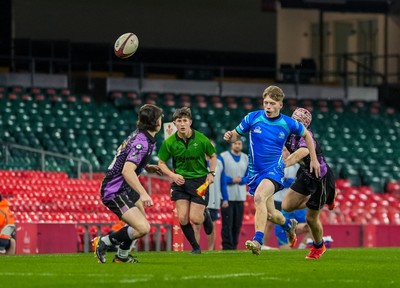 111225 - Ysgol Gymraeg Bro Morgannwg v Ysgol Gyfun Gymraeg Bro Myrddin - U18 Schools and Colleges Champions of Champions - Tomos Provis of Ysgol Gymraeg Bro Morgannwg kicks the ball past Rhys Jones of Ysgol Gyfun Gymraeg Bro Myrddin